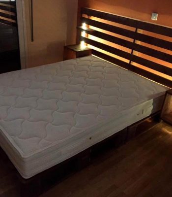 wooden palled bed with storage headboard